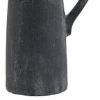 Detail of the jug's lower charcoal-grey body and rounded base edge, with fine pale irregular lines and the lower handle attachment visible.