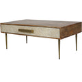 Angled view of the coffee table with its chevron inlay drawer closed, wood top and sides, and slender aged gold legs.