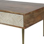 Close-up of the coffee table's front corner where the chevron inlay meets the grained wood side and top.