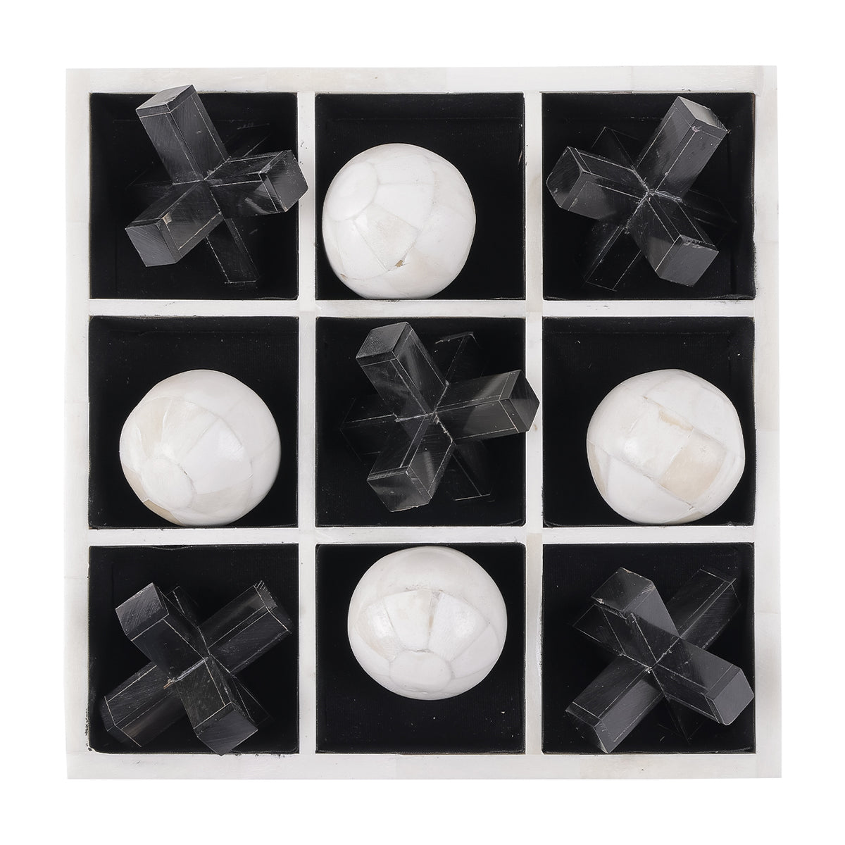 Overhead view showing the three-by-three black grid, off-white dividers and alternating black crosses and pale bone noughts.