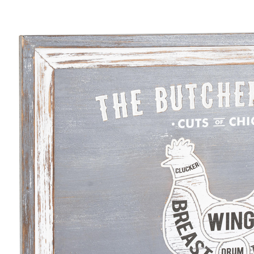 Close-up of the plaque's upper left corner, showing the distressed grey and white border, cropped butcher's-guide lettering and the chicken's Clucker label.