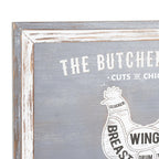 Close-up of the plaque's upper left corner, showing the distressed grey and white border, cropped butcher's-guide lettering and the chicken's Clucker label.