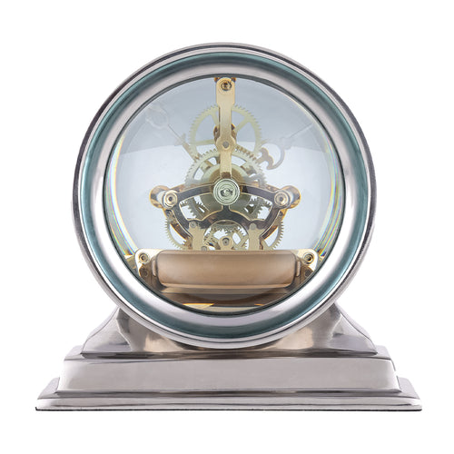 Rear view of the clock showing layered gold-toned wheels and a horizontal cylindrical element through clear glass.