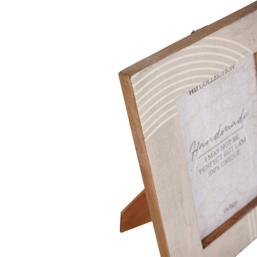 Close angled view of the frame’s upper-left corner, showing fine white arcs across the pale finish, brown outer edge and rear easel.