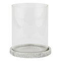 Front view of a clear cylindrical candle lantern on a shallow pale grey round base with mottled markings.