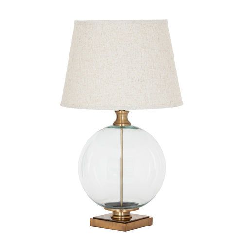 Clear Spherebody Table Lamp on a white background, with a pale tapered shade, transparent round body and brass-toned square base.