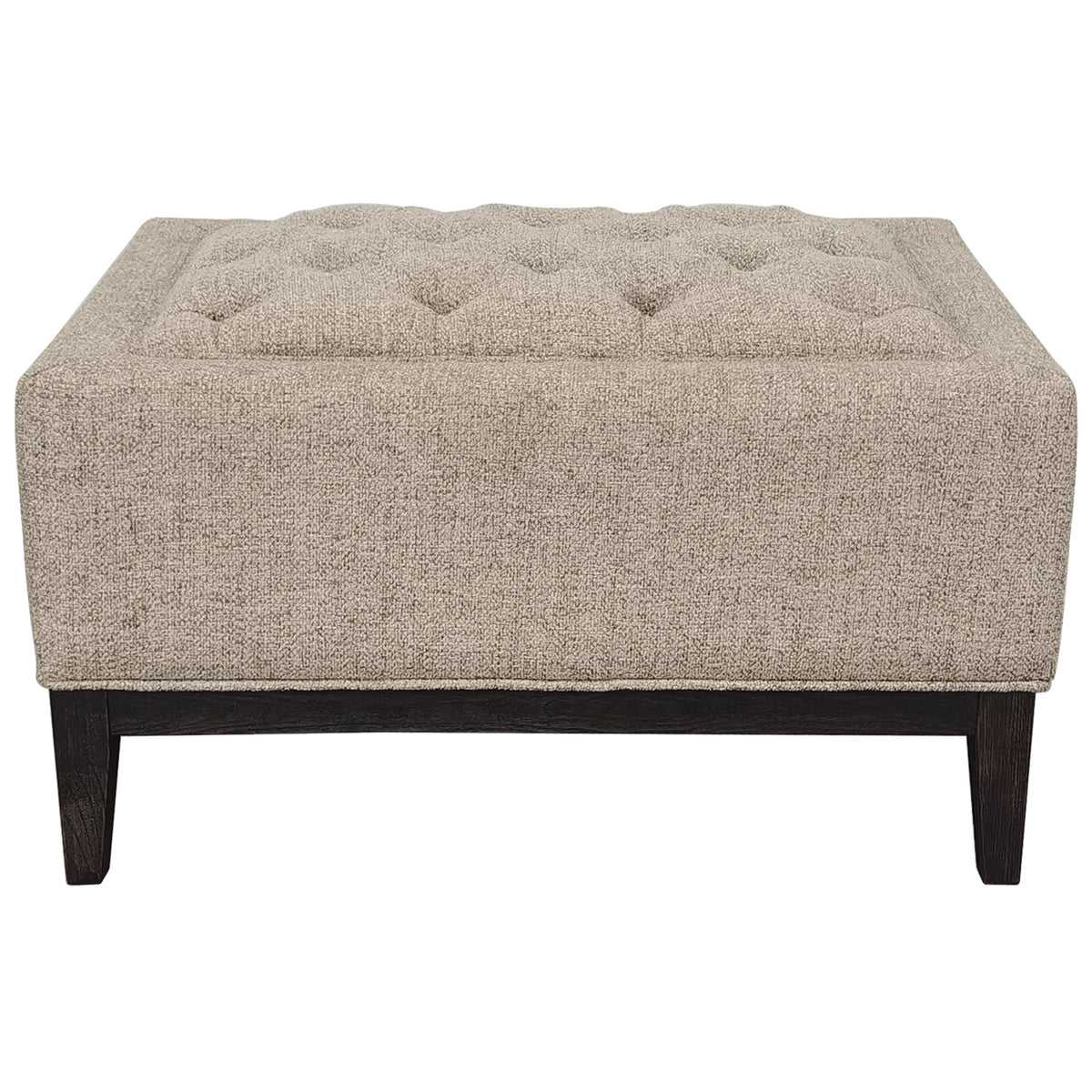 Taupe rectangular footstool on a white background, showing its buttoned top, upholstered sides and dark wooden base with tapered legs.