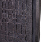 Close-up of irregular embossed blocks, the rough panel edge and distressed black frame.
