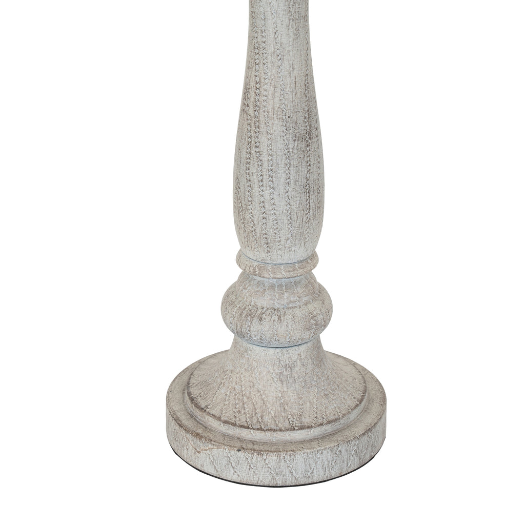 Close-up of the lamp's lower stem and broad circular foot, showing curved collar details and fine darker markings through the pale finish.