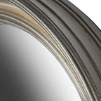 Close-up along the curved frame edge showing silver highlights, dark grooves and fine surface texture beside the glass.