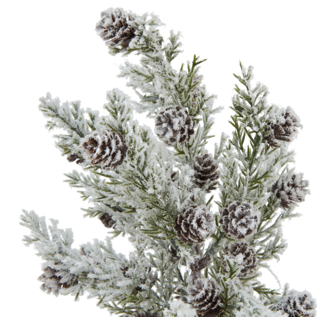 Close-up of brown layered cone shapes among green needle-like branches covered with a fluffy white snow effect.