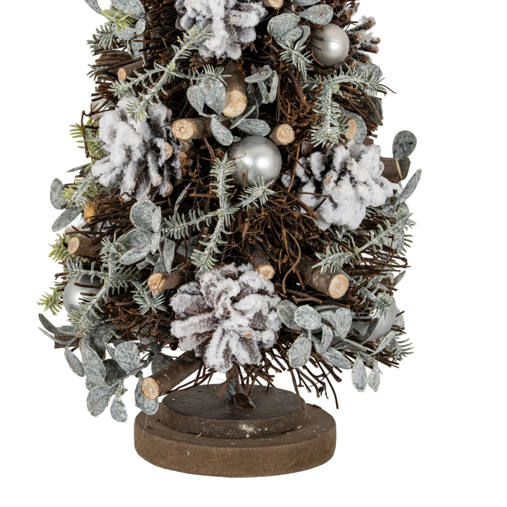 Close-up of the lower tree showing white-frosted pinecones, cut twig ends, pale green-grey sprigs and silver-toned spheres above the layered base.