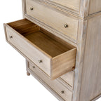 Angled detail of an open lower drawer, showing its empty interior, paired knobs and the framed closed drawers around it.