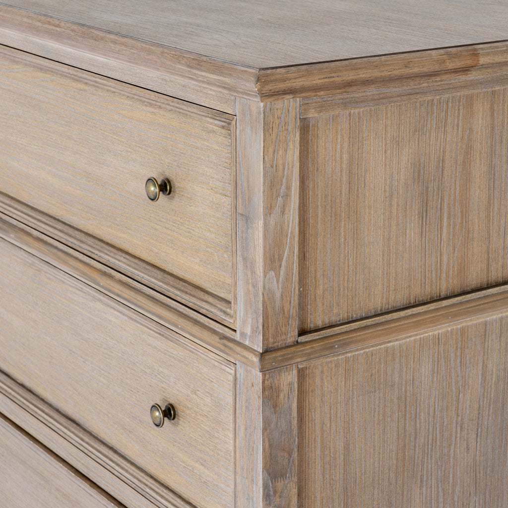 Close view of the chest's upper corner, showing the projecting top, shaped drawer borders and grain patterning on the side.