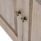 Close-up of the dresser's two dark gold-toned door knobs against the pale grain and shaped panel borders.