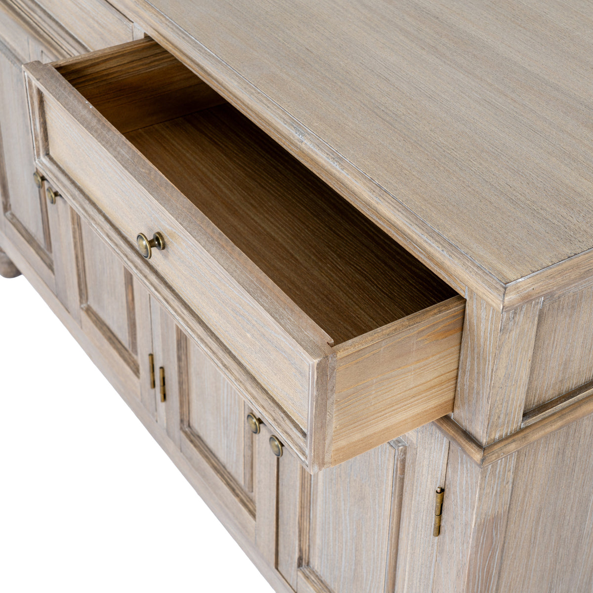 View from above of an open top drawer, showing its empty interior, framed front and brass-coloured knob beneath the sideboard top.