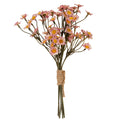 Full view of a pink and cream artificial daisy bunch with yellow centres, branching olive-grey stems and tan cord wrapped around the lower stems.