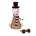 Seated snowman decoration with black top hat, striped scarf, cord arms and bead legs extended forwards.
