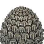 Close-up of the acorn crown showing overlapping rounded scales, dark recesses and light reflecting from the glossy crackle finish.