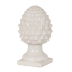 Off-white acorn ornament with an oval scale-covered crown, flared pedestal and square foot against a white background.