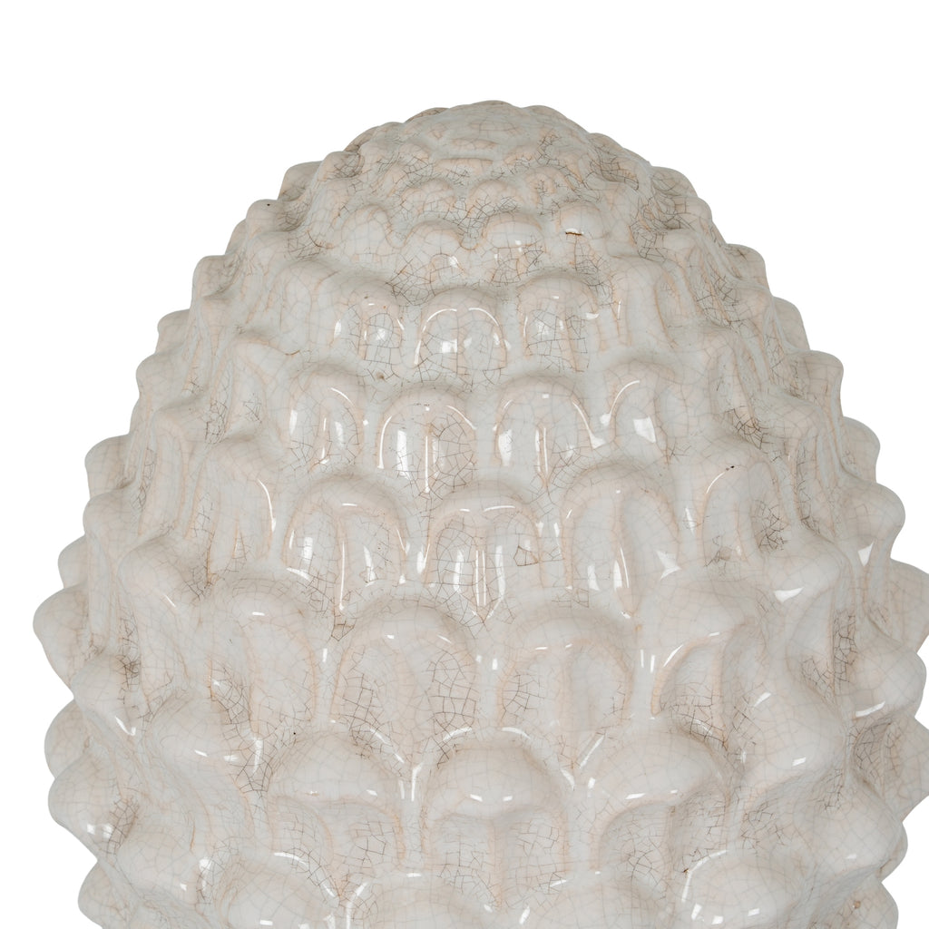Close-up of the ornament's rounded overlapping scales, showing glossy highlights and fine grey-beige crackle lines.
