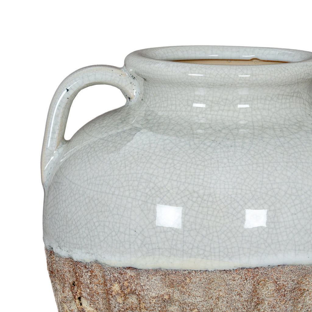 Close-up of the vase shoulder and left handle, with pale crackle glaze meeting the rough mottled brown surface below.