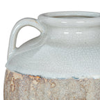 Close-up of a curved shoulder handle and the uneven edge where the pale crackle glaze meets the rough brown finish.