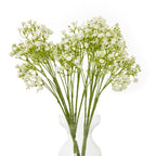 Several cream artificial gypsophila stems arranged in a clear waisted vase, forming a broad spray of small flowers against a white background.