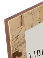 Close-up of the frame's upper left corner showing the joined cream resin patches, brown markings and exposed brown side edge.