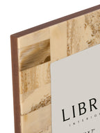 Close-up of the frame's upper left corner showing cream and beige resin sections with brown swirling patterns.