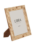 Angled view of the cream patchwork photo frame with a printed insert and rear easel visible.