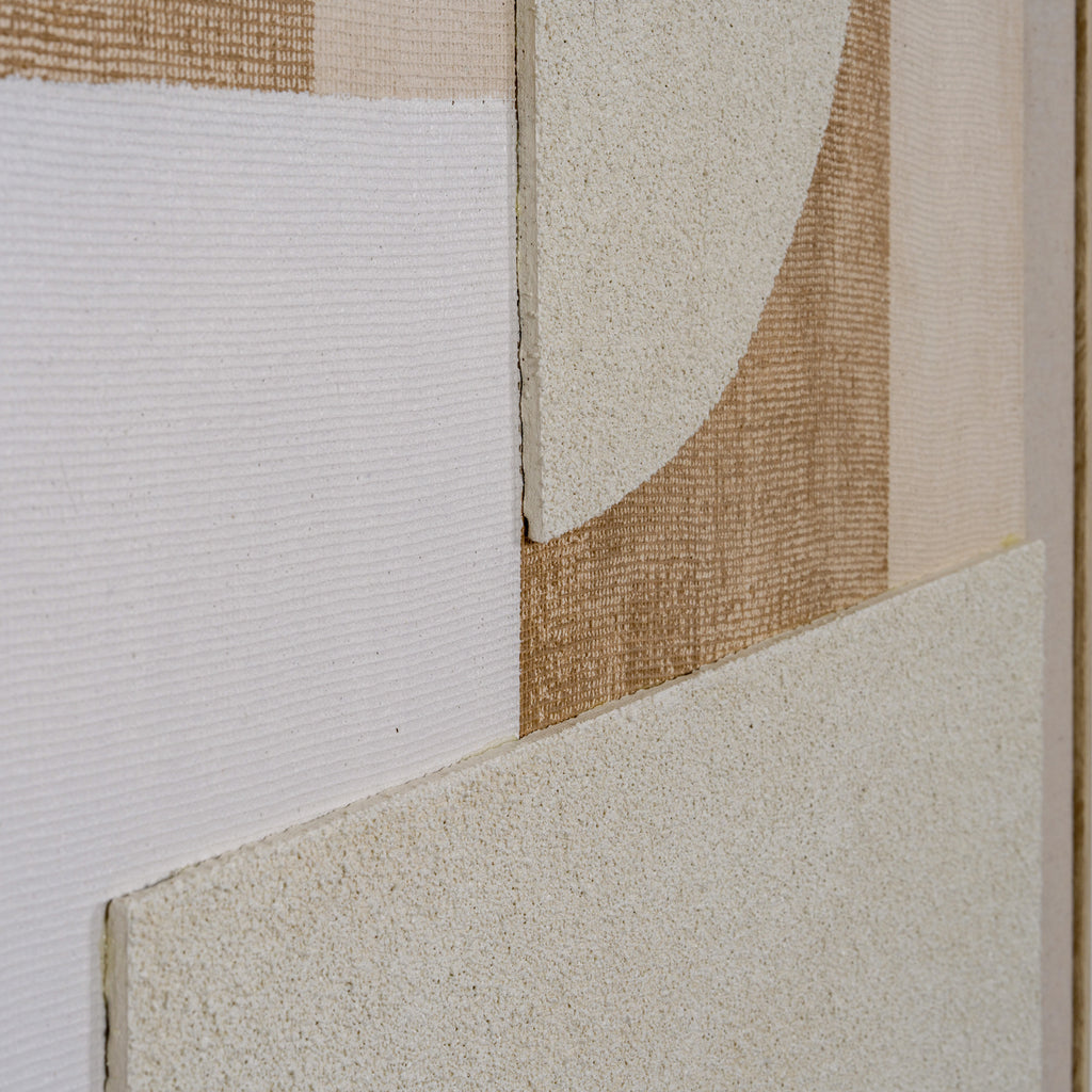 Close-up of the raised cream semicircle beside white horizontal ridges and an ochre-brown grid, with a granular cream panel below.