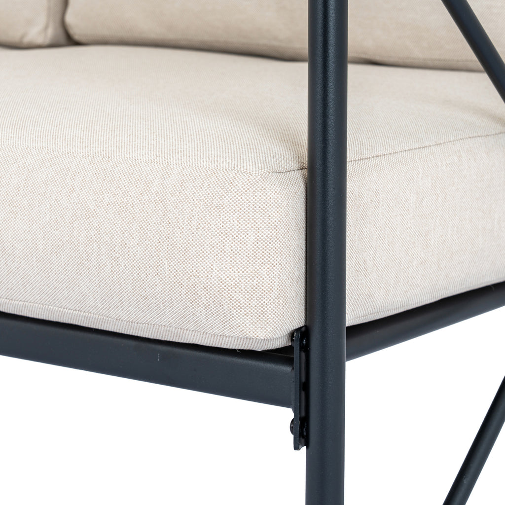 Close view of a beige seat cushion's fine woven texture and stitched edge beside a black frame post.