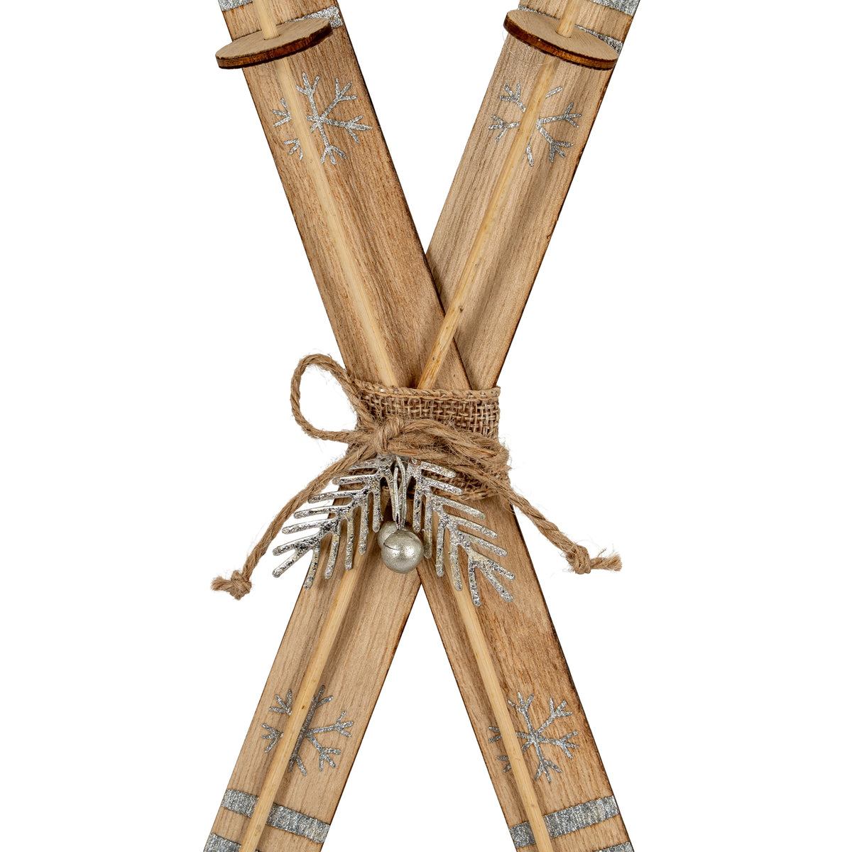 Close-up of the ski ornament's woven-looking centre band and twine bow, with a silver-coloured sprig and spherical bell-like detail below.