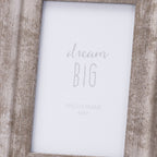 Close-up of the photo frame's rubbed crosshatch finish beside the white dream BIG insert, showing the inward slope along both sides.