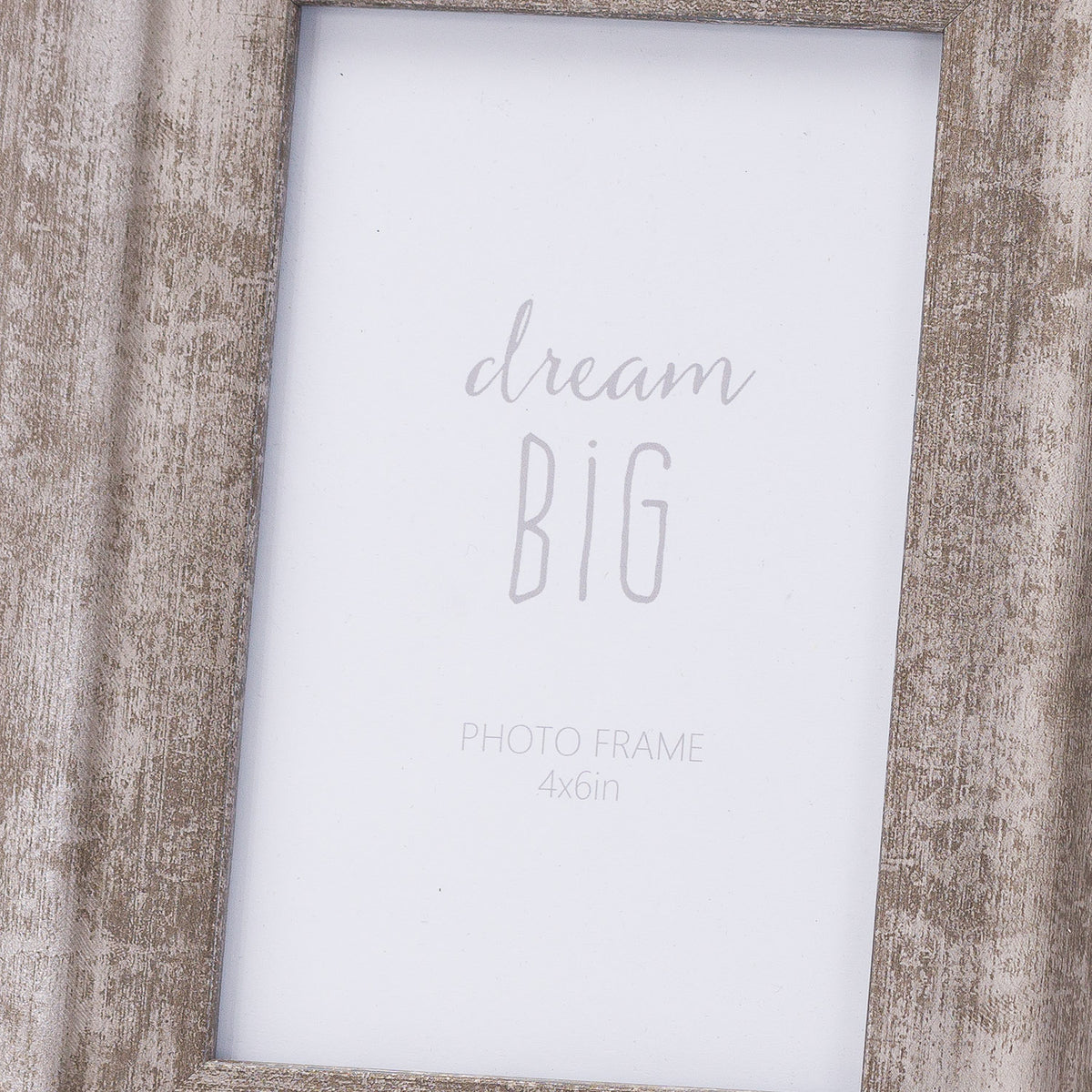 Close-up of the photo frame's rubbed crosshatch finish beside the white dream BIG insert, showing the inward slope along both sides.