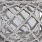 Close-up of the lantern's crossing lattice ribs, with dark speckles and distressed markings across the pale finish.