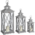 Three grey wooden lanterns in descending sizes, each with crossed side bars, a tiered roof, a top loop and a cream candle pictured inside.