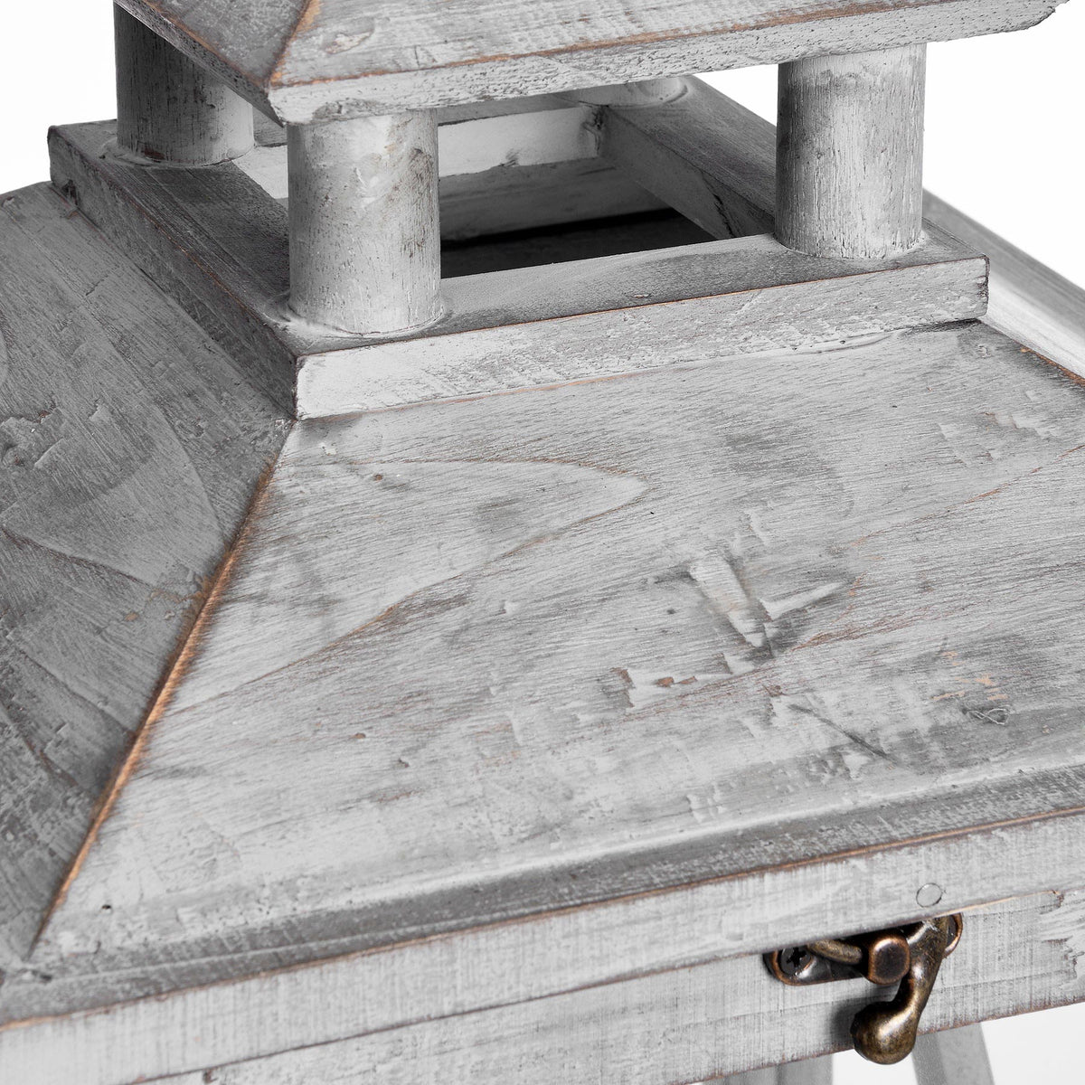 Close view of the lantern's pitched roof and open upper tier, showing the rubbed grey wood finish and bronze-toned front catch.