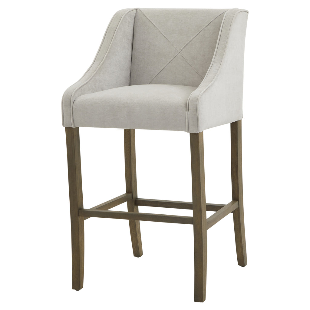 Crossstitch Counter Stool viewed from the front at an angle, showing its pale seat, X-stitched back, low arms and tall brown legs.