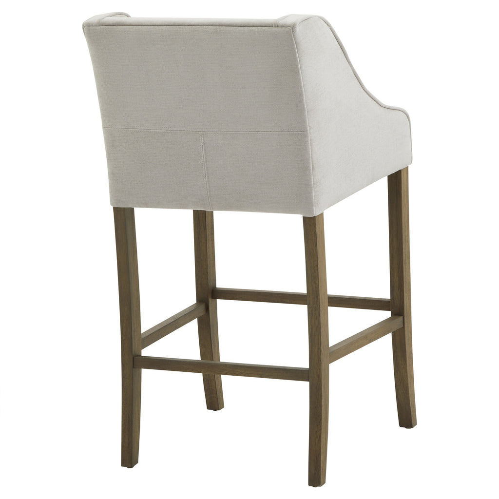 Rear angled view of the Crossstitch Counter Stool, with a plain pale back, piped curved sides and rectangular stretchers between brown legs.