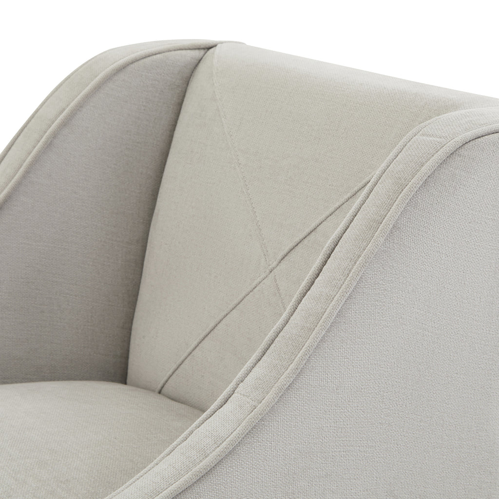 Close-up of the stool's pale textured covering, diagonal back stitching and piping along the curved arm.