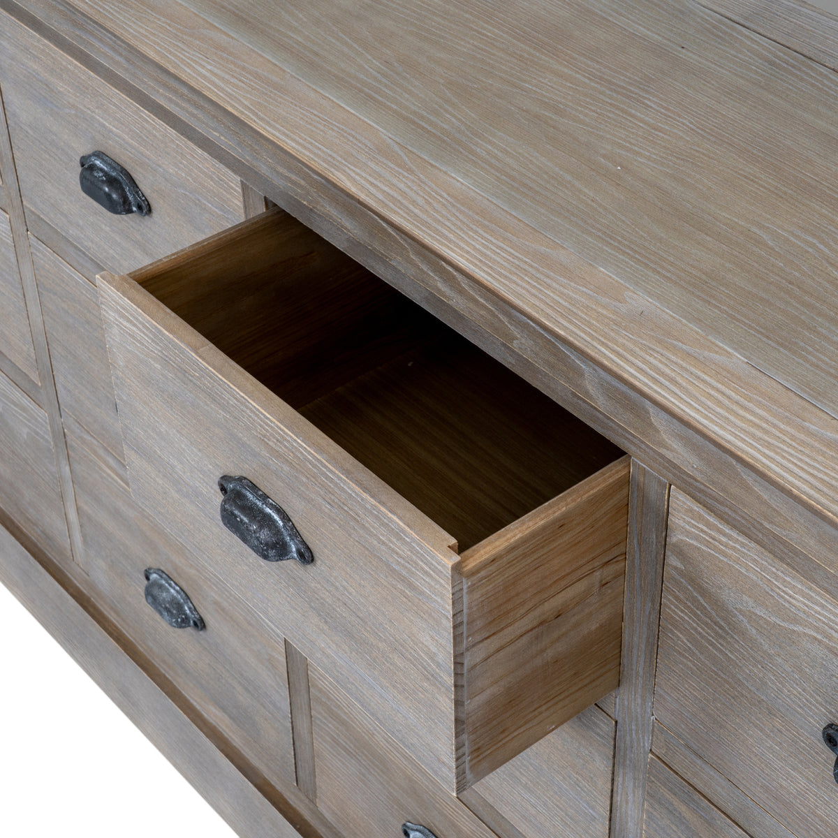 Close view from above of one drawer shown open beneath the broad top, with a dark cup pull and pale grain markings on the front.
