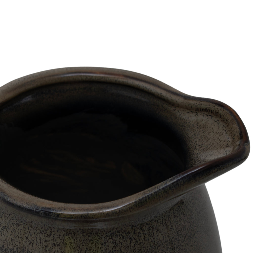 Close-up looking into the vase's irregular oval opening, showing the rolled rim, projecting lip and mottled olive-brown finish.