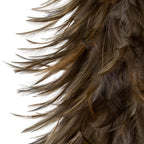 Close-up of the decorative tree's layered feather-like surface, showing fine strands and long curved tips in grey and warm brown.