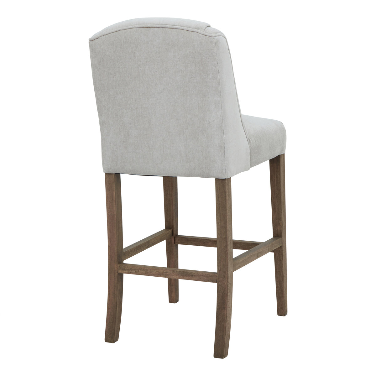 Rear three-quarter view showing the stool's broad pale grey covered back, piped upper edge and brown legs.