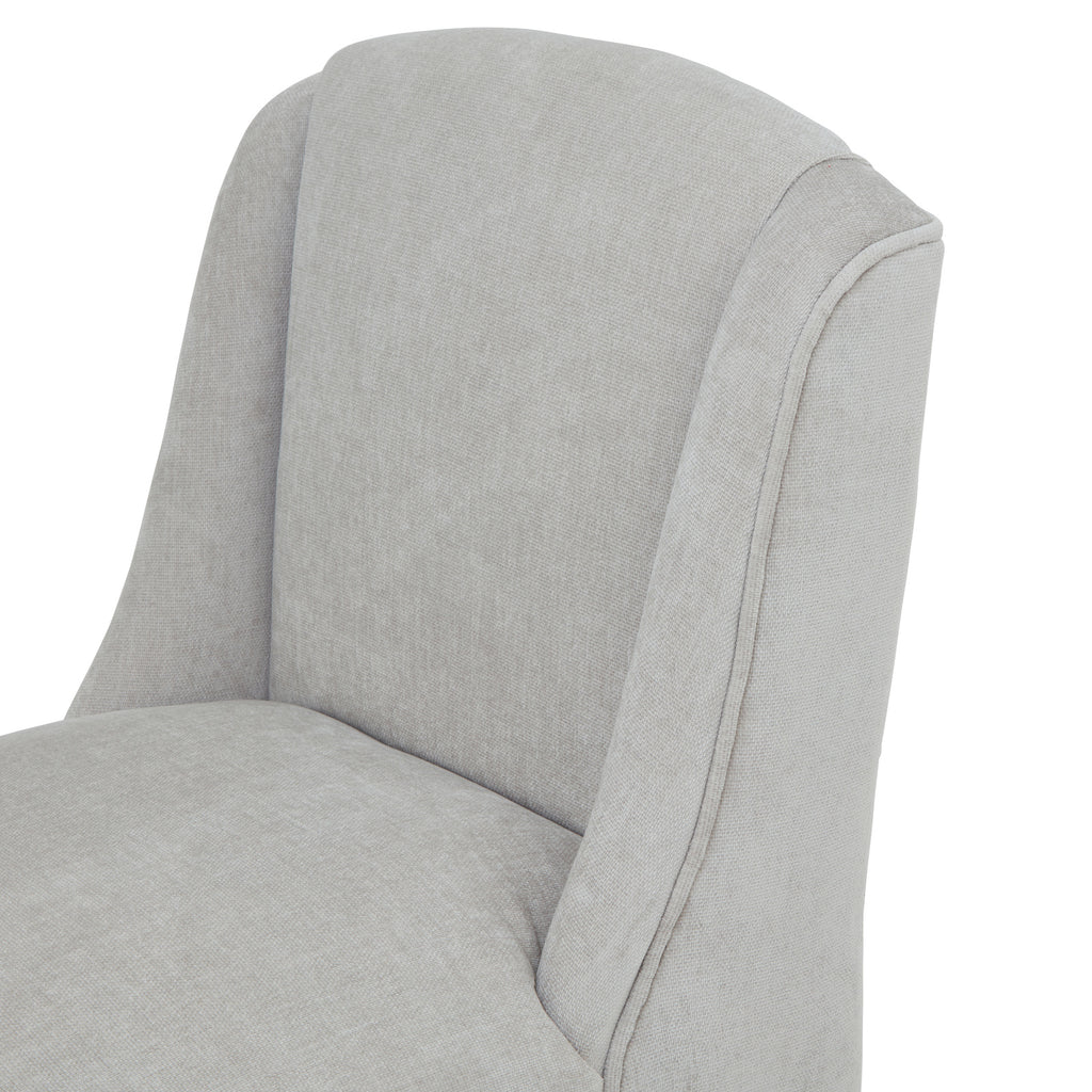 Close-up of the curved pale grey back and sweeping side wings, with fine woven texture and piping along the outer edge.