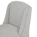 Close-up of the curved pale grey back and sweeping side wings, with fine woven texture and piping along the outer edge.