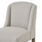 Close view of the chair’s curved upholstered back, defined side wings and rounded seat edge.