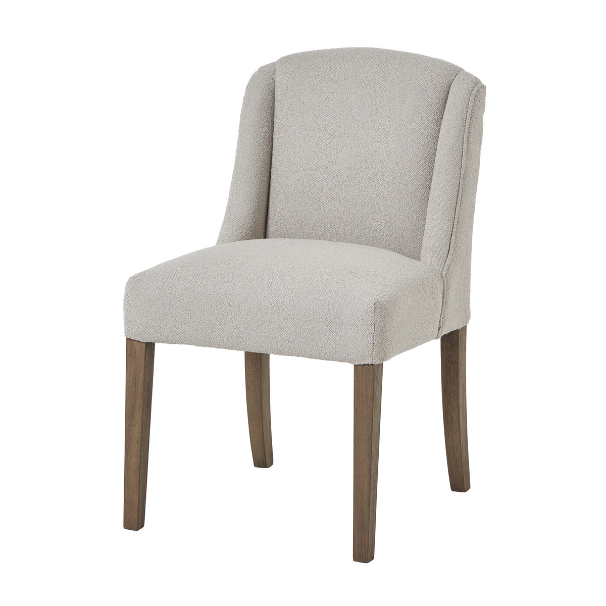 Three-quarter view of a pale upholstered dining chair with a curved wing back and four brown wooden legs on white.